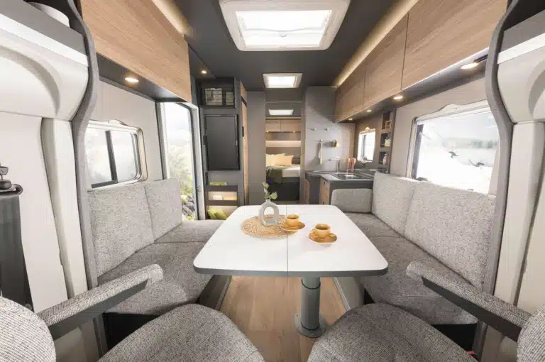 Hellgrau melierte Sitzpolster Bänke mit weißem Tisch in der Mitte im Wohnwagen Trend von Dethleffs