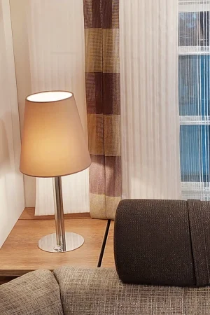 Vorhänge mit Blockstreifen in warmen Beige-, Braun- und Goldtönen vor einem Fenster mit transparentem Sichtschutz.